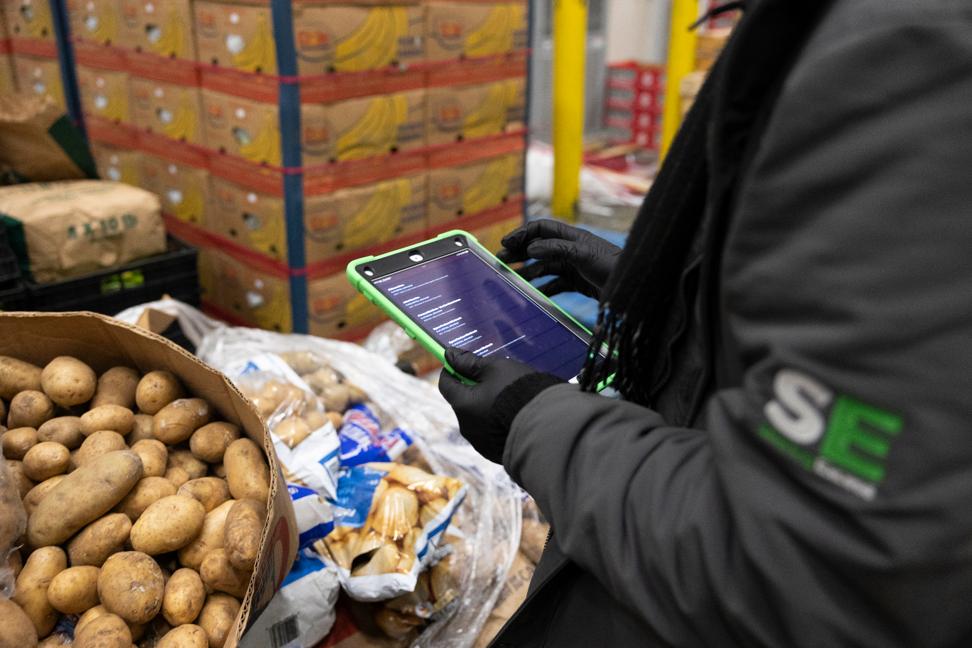 Sharing Excess team member using a tablet running the proprietary tech platform in the warehouse