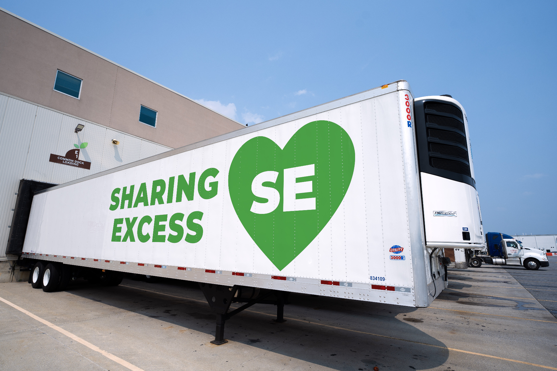 Refrigerated Sharing Excess box truck branded with the green SE heart logo